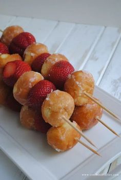 strawberries and donuts are arranged on skewers