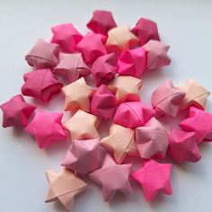 pink and white origami stars are arranged in a circle on a table top