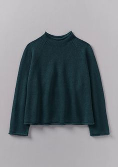 a dark green sweater hanging on a hanger, with the top half turned down