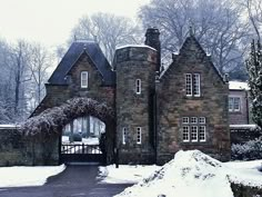 a large brick building with a gate in front of it and snow on the ground