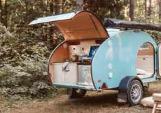 an old camper trailer is parked in the woods