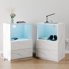 two white nightstands with shoes on them in a room