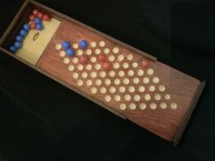 a wooden board game with many different colored balls