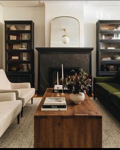 a living room with two couches and a coffee table in front of a fireplace