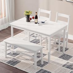 a white dining table with four chairs and two bottles of wine on top of it