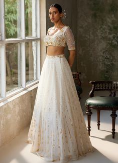 Embrace timeless elegance with the exquisite Ivory Embroidered Lehenga Set, crafted from pure silk organza. The full-length ivory lehenga showcases intricate hand-embroidery, adding a touch of opulence and tradition to the ensemble. Delicate motifs dance across the ethereal fabric, shimmering subtly in the light. Paired with matching half sleeved blouse features meticulous hand-embroidery, enhancing its luxurious appeal. A beautifully completed dupatta with hand-embroidered borders and motifs th Ethereal Fabric, Ivory Lehenga, Lehenga Dupatta, Organza Lehenga, Vacuum Storage, Net Lehenga, Embroidered Lehenga, Intimate Wedding Ceremony, Indian Wedding Wear