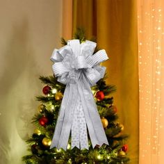 a decorated christmas tree in front of a window