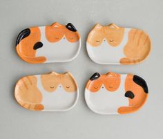 four orange and white plates with cats on them