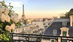 a balcony with white flowers and the eiffel tower in the background