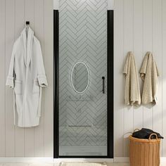 a bathroom with a glass shower door and white towels hanging on the wall next to it