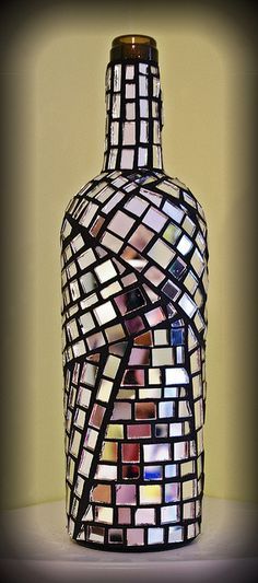 a mosaic glass bottle sitting on top of a table