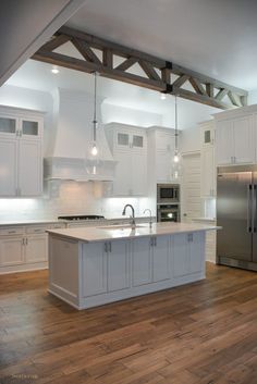 a large kitchen with white cabinets and stainless steel appliances