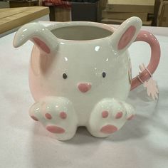 a pink and white ceramic animal mug sitting on top of a table