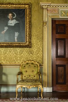 an old chair in front of a painting on the wall