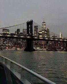 the city skyline is lit up at night as seen from a boat on the water