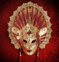 Crafted in sultry red and gold, this decadent mask's most alluring feature is its extended fan-shaped headpiece. Composed of applique, hand-bent metal, and crystals, this mask will lend its wearer an air of regal seductiveness that won't be easily forgotten by those who behold it. Handmade in Italy and is accompanied b Luxury Artistic Masks For Carnival, Luxury Artistic Red Masks And Prosthetics, Awesome Masks, Italian Masks, Venice Carnevale, Beautiful Masks, Decorative Masks, Venice Mask, Venetian Masquerade Masks