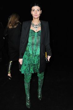 a woman in green dress and black jacket