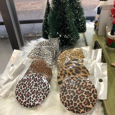 four leopard print plates sitting on top of a table next to a small christmas tree