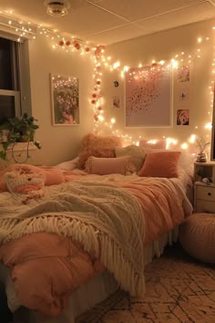 a bedroom with lights strung from the ceiling and blankets on the bedspread,