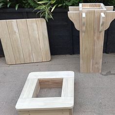 three wooden planters sitting next to each other in front of a potted planter