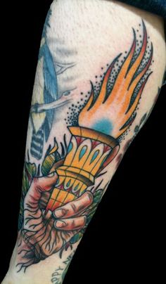 a person with a tattoo on their arm holding a lighter