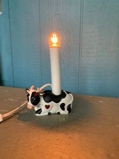 a cow shaped candle holder with a light on it