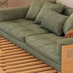 a green couch sitting on top of a wooden floor