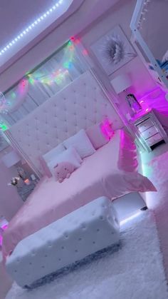 a bedroom decorated in pink and white with lights on the ceiling, bedding and rugs