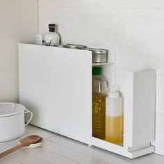 a white cabinet filled with bottles and cooking utensils