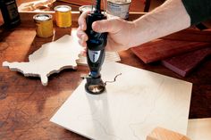 a person is using a drill to fix a piece of wood on a table with other tools