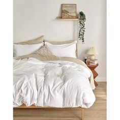 an unmade bed with white linens and pillows on top of it in a bedroom