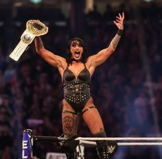 an image of a woman holding a trophy in the air with her arms raised up