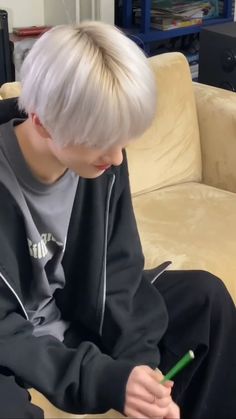 a person sitting on a couch with a pen in their hand and looking at something