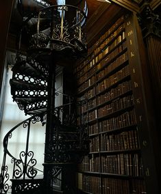 a spiral staircase in front of a bookshelf