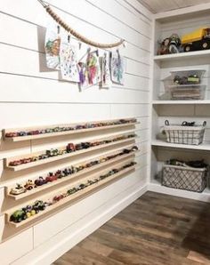 a room with shelves filled with toy cars and toys on the wall, along with other items