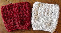 two knitted mittens sitting on top of a wooden floor next to each other