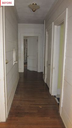 an empty hallway with white walls and wood floors is seen in this image from the front door