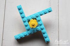 a lego letter with a yellow flower on it