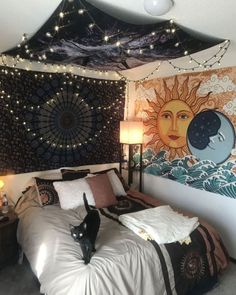 a cat is standing on the bed in front of a tapestry wall hanging above it