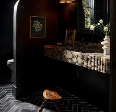 a bathroom with a sink, mirror and stool on the floor in front of it