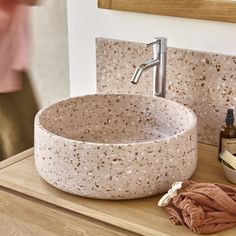 a bathroom sink sitting on top of a wooden counter