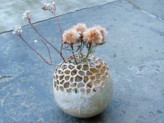 a vase with flowers in it sitting on the ground