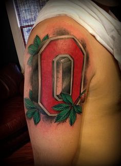 a man with a tattoo on his arm that has the letter o painted on it