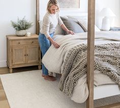 a woman sitting on top of a bed in a bedroom