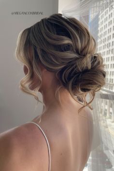 the back of a woman's head with her hair in a low bun