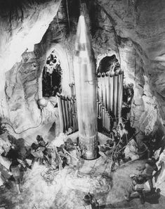 an old black and white photo of people in a cave