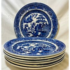 a stack of blue and white plates sitting on top of each other in front of a white background