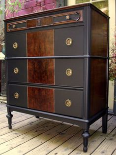 an old dresser is painted black and brown