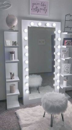 a mirror with lights on it and a stool in front of the mirror that is lit up