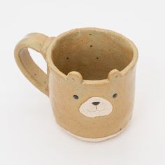 a ceramic mug with a bear face on it